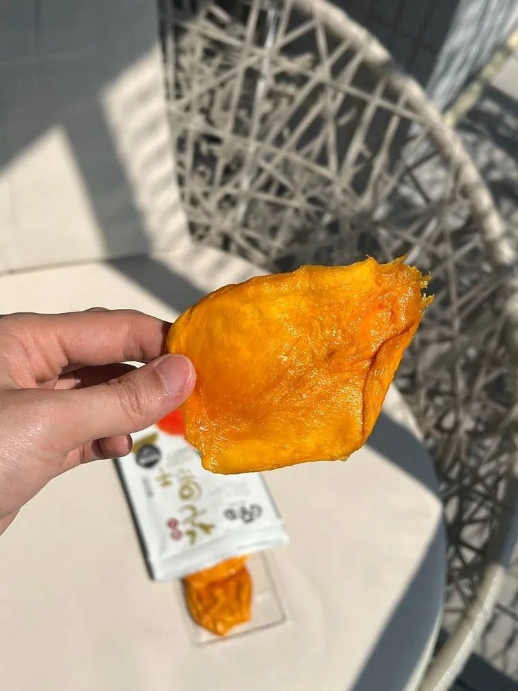 手拿一片愛文芒果乾,可看到厚度與顏色